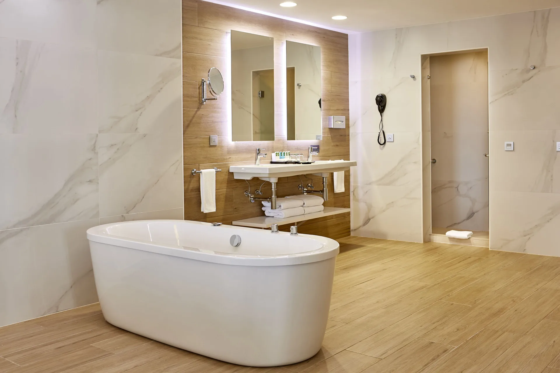 Suite bathroom with freestanding tub, double mirrors, vanity, and shower at Hotel Riu Palace Punta Cana.