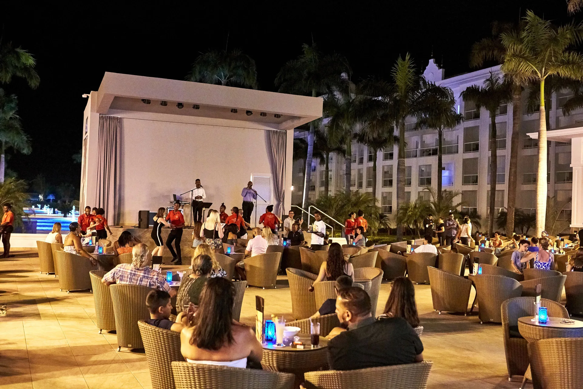 Outdoor nighttime show with stage and lounge seating at Hotel Riu Palace Punta Cana.