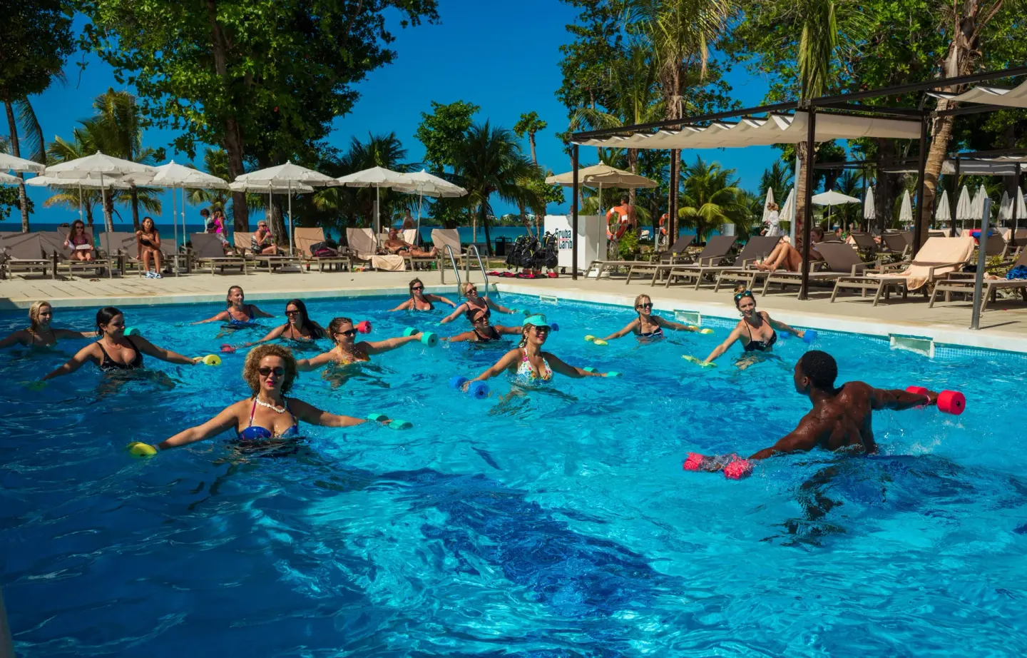 Guests take an aqua fitness class in the pool at Hotel Riu Palace Tropical Bay.