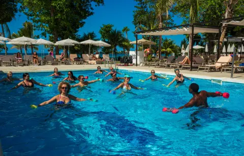 Guests take an aqua fitness class in the pool at Hotel Riu Palace Tropical Bay.