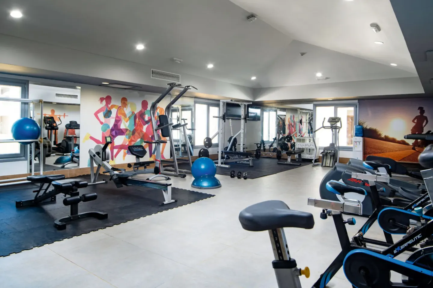 Fitness room with cardio machines and strength equipment at Hotel Riu Palace Tropical Bay.