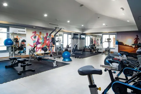 Fitness room with cardio machines and strength equipment at Hotel Riu Palace Tropical Bay.
