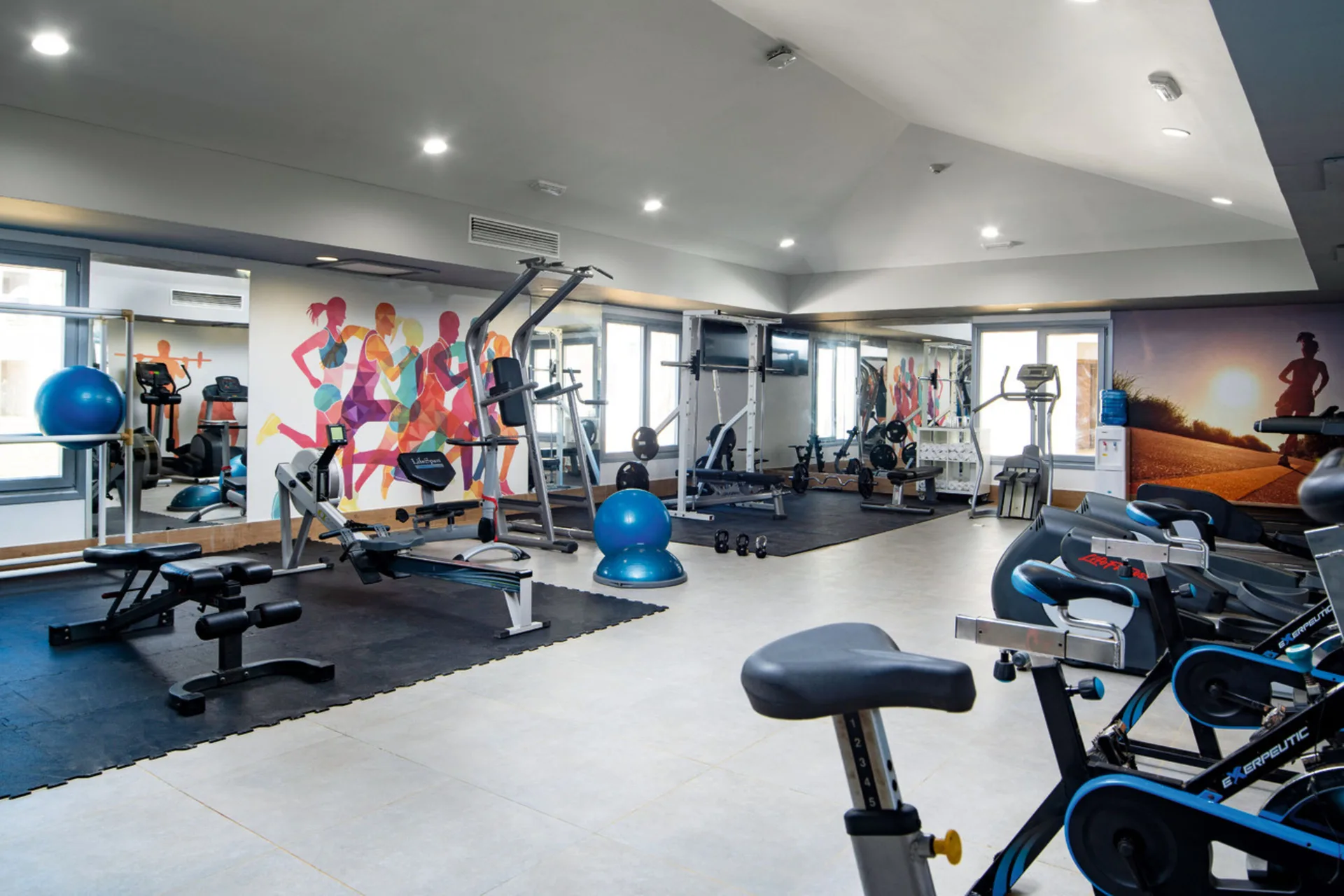 Fitness room with cardio machines and strength equipment at Hotel Riu Palace Tropical Bay.