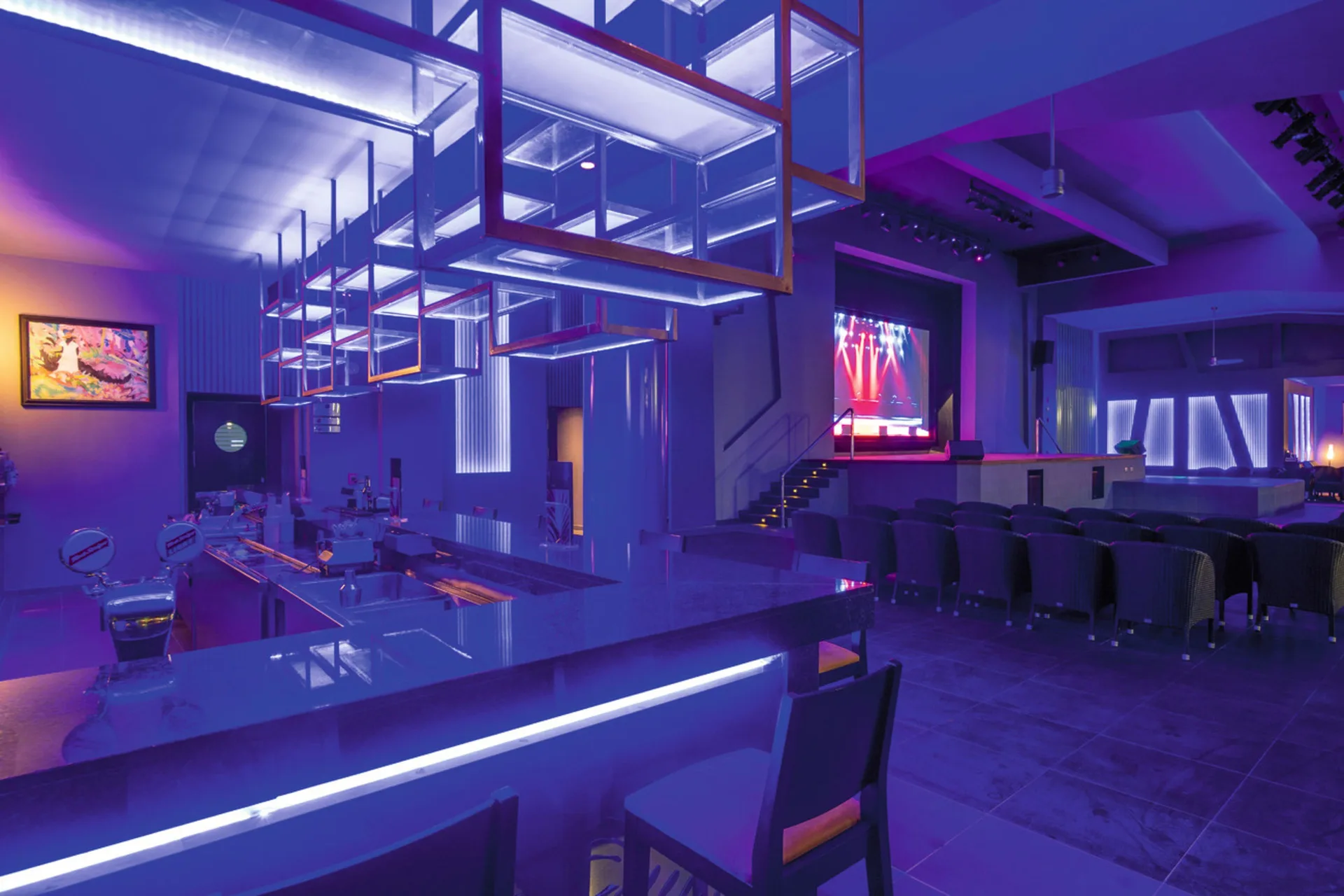 Blue-lit lounge bar overlooking a stage at Hotel Riu Palace Tropical Bay.