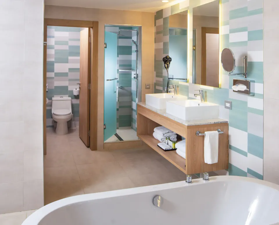 Ocean View suite bathroom with double sinks and shower at Hotel Riu Palace Tropical Bay.