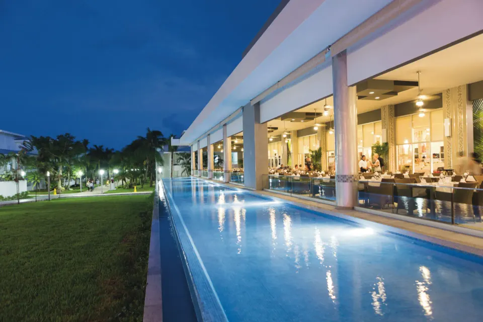 Evening exterior view of the resort terrace and reflecting pool at Hotel Riu Playacar