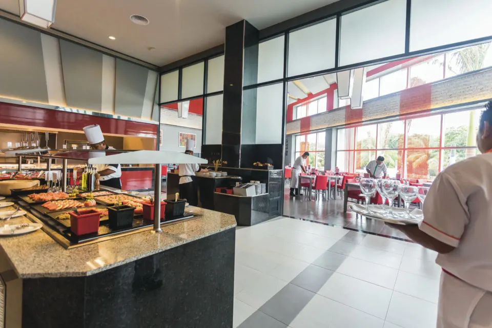 Buffet station and dining room interior at Hotel Riu Playacar.