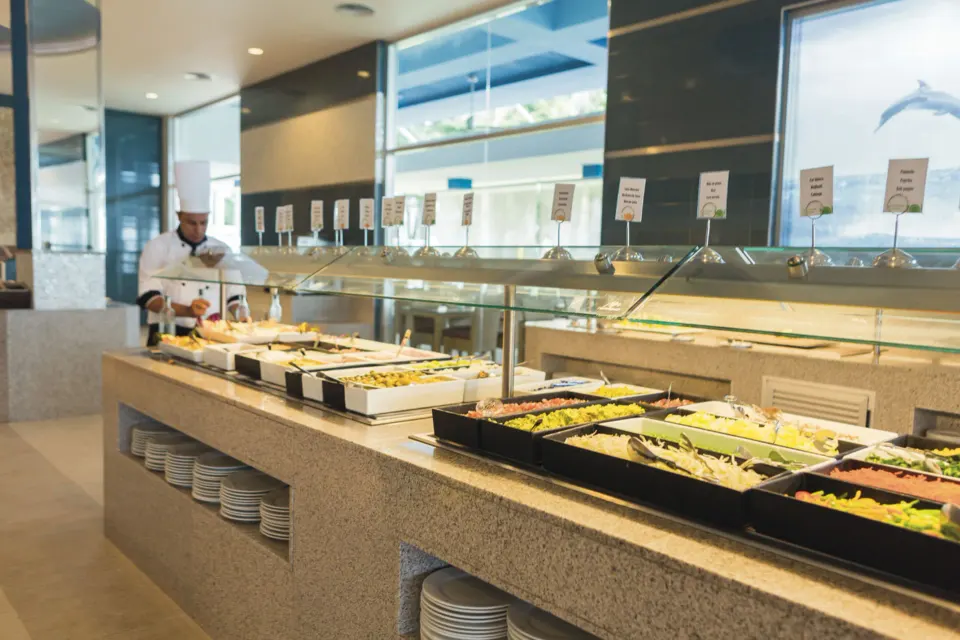 Buffet line with labeled stations and a chef at Hotel Riu Playacar