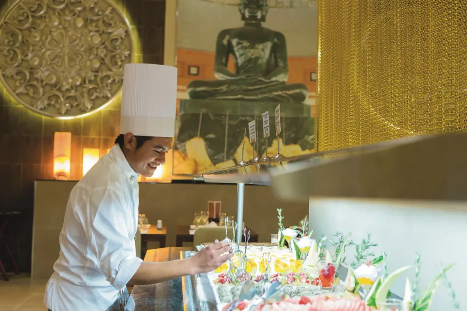 Chef plating desserts at a decorated buffet station at Hotel Riu Playacar