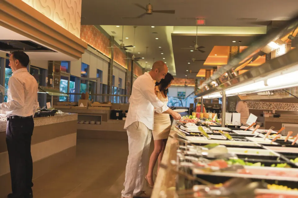 Couple selecting food from the buffet salad bar at Hotel Riu Playacar