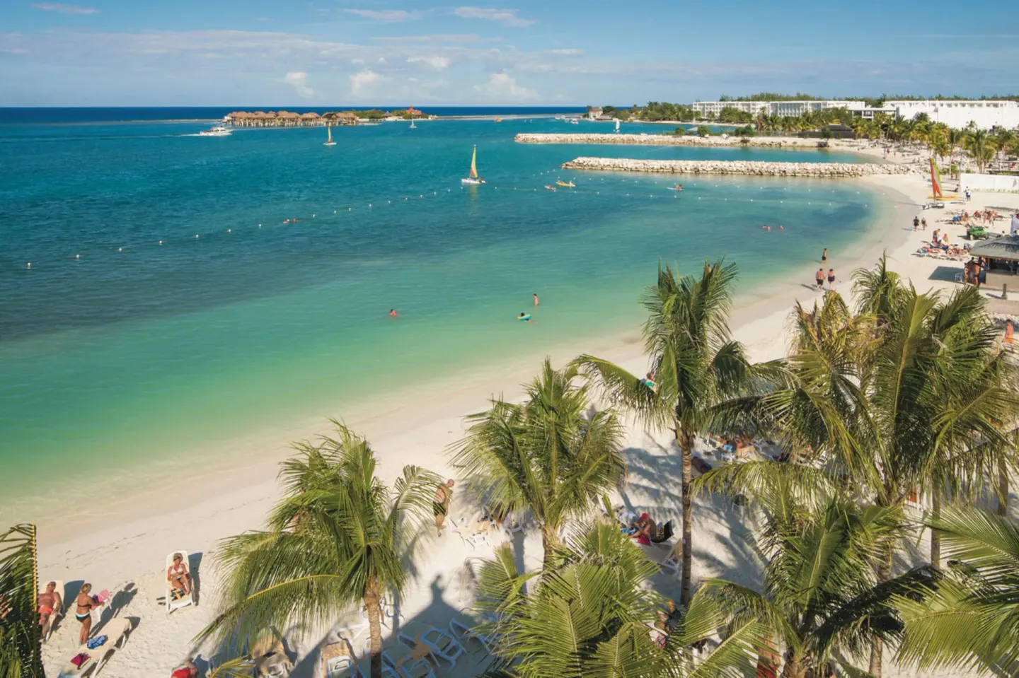 Aerial view of the beach, palms, and turquoise water at Hotel Riu Reggae.