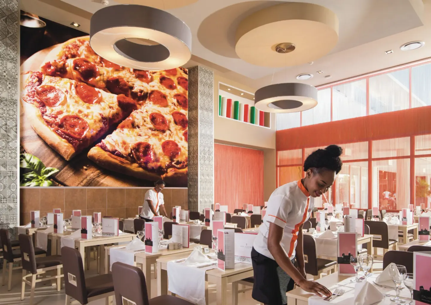 Italian restaurant dining room with a large pizza mural at Hotel Riu Reggae.