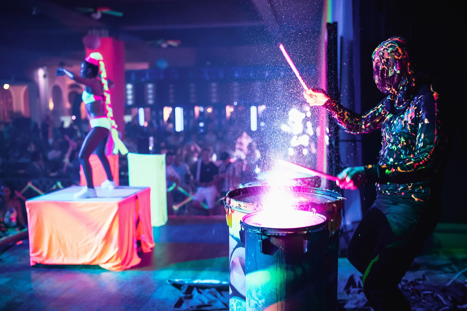 A neon-lit drummer performs onstage during a show at Hotel Riu Republica.