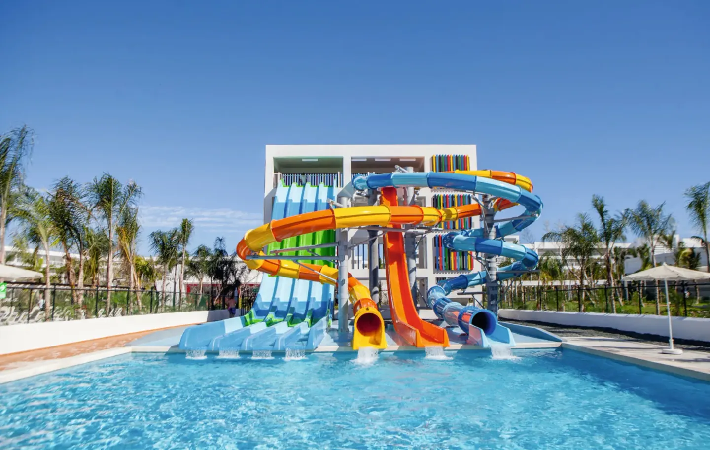 Colorful waterslide tower and splash pool at Hotel Riu Republica.