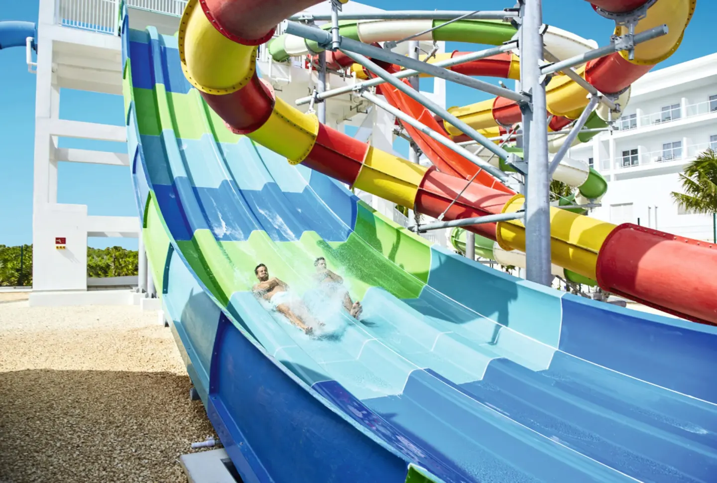 Guests splash down a wide blue waterslide at Hotel Riu Republica.