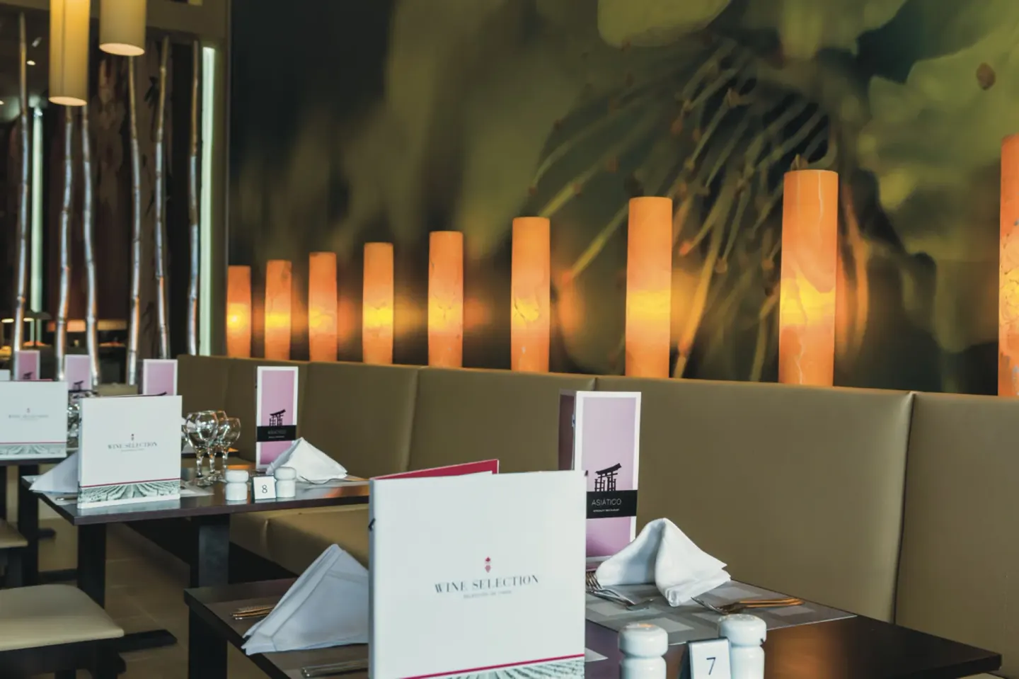 Asian restaurant booth seating with glowing wall lights at Hotel Riu Republica.