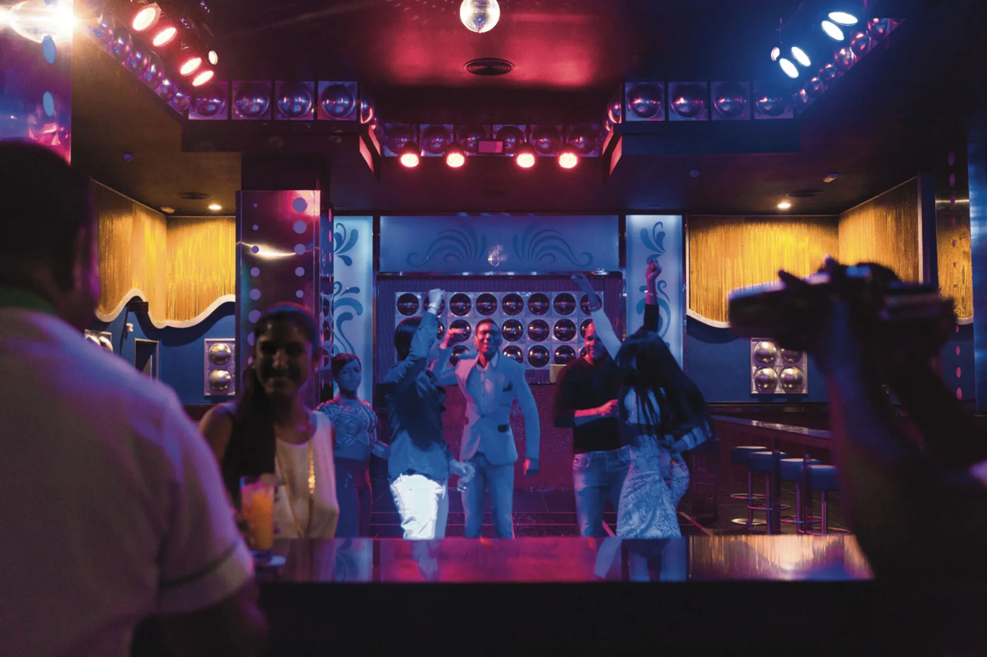 Guests dancing under colorful lights in a nightclub at Hotel Riu Republica.