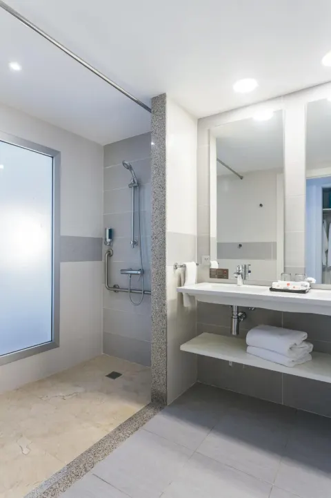 Bathroom in a Room Tropical View at Hotel Riu Republica with walk-in shower, vanity, towels, and mirror.