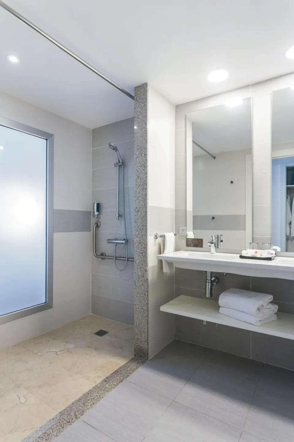 Bathroom in a Room Tropical View at Hotel Riu Republica with walk-in shower, vanity, towels, and mirror.