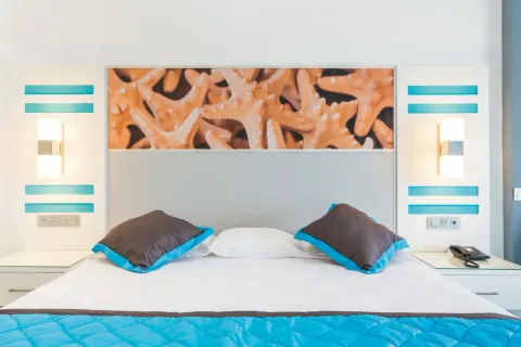 Close view of a guest room bed with starfish artwork at Hotel Riu Republica.