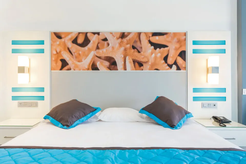 Close view of a guest room bed with starfish artwork at Hotel Riu Republica.