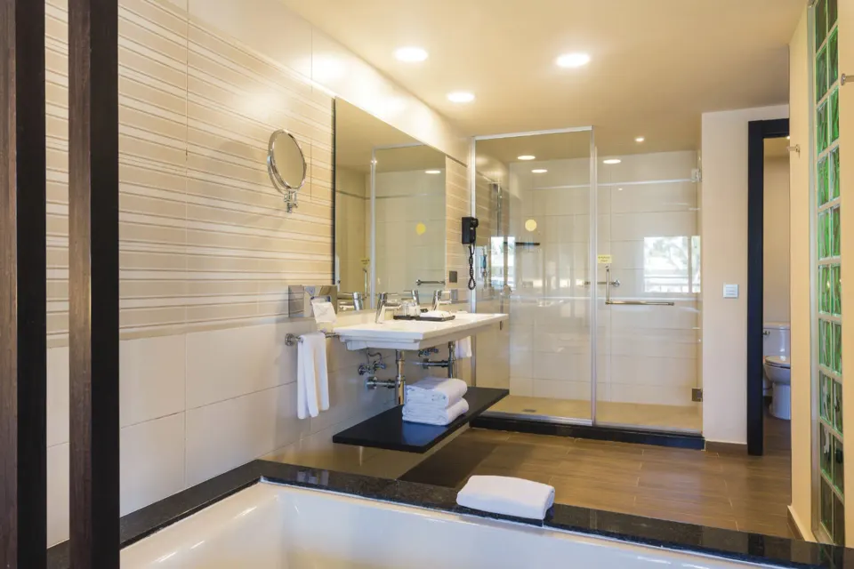 Suite bathroom with tub, vanity, glass shower, and separate toilet area at Hotel Riu Republica.