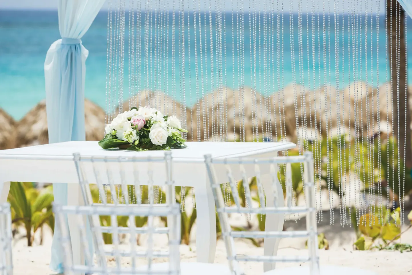 Beach wedding table with flowers and ocean backdrop at Hotel Riu Republica.
