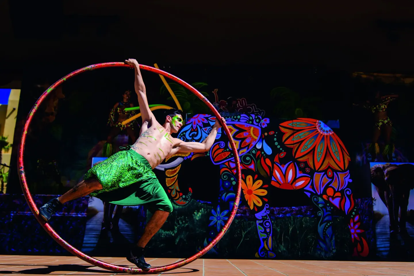 An acrobat performs inside a large wheel on stage at Hotel Riu Santa Fe.