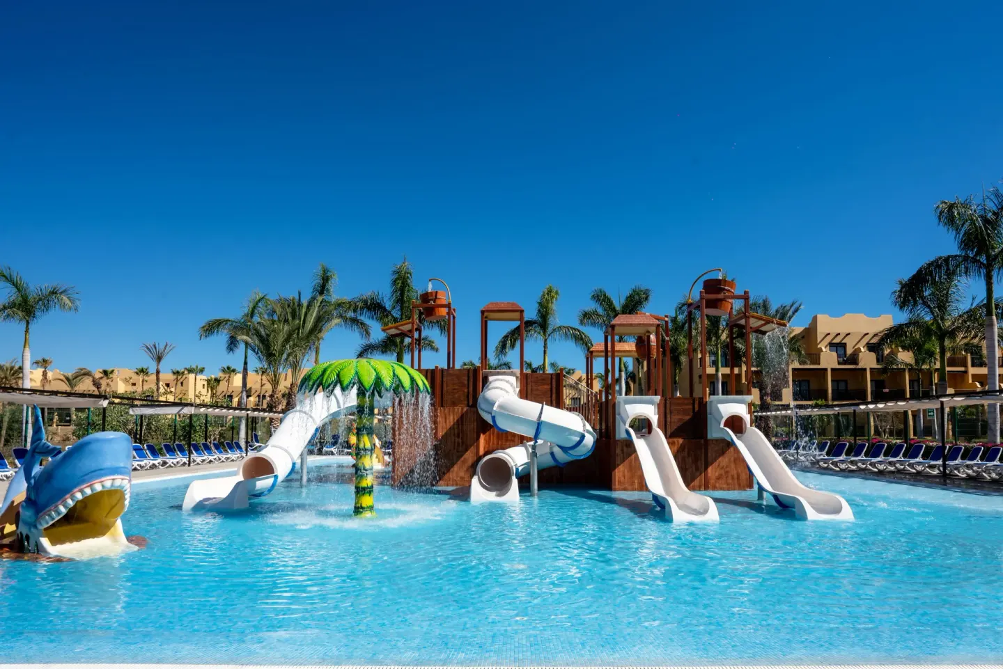 Children's splash pool with multiple slides and water sprays at Hotel Riu Santa Fe.