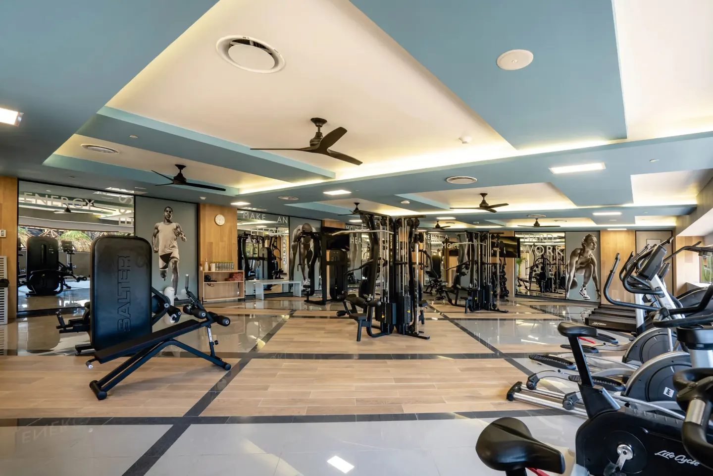 A modern gym with cardio and strength equipment at Hotel Riu Santa Fe.