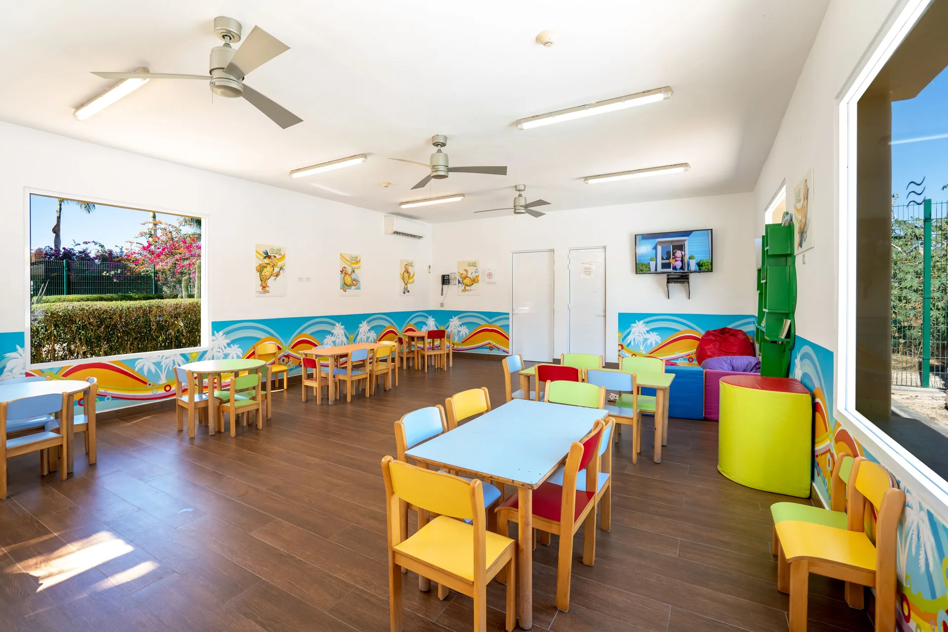 Colorful children’s activity room with small tables at Hotel Riu Santa Fe.
