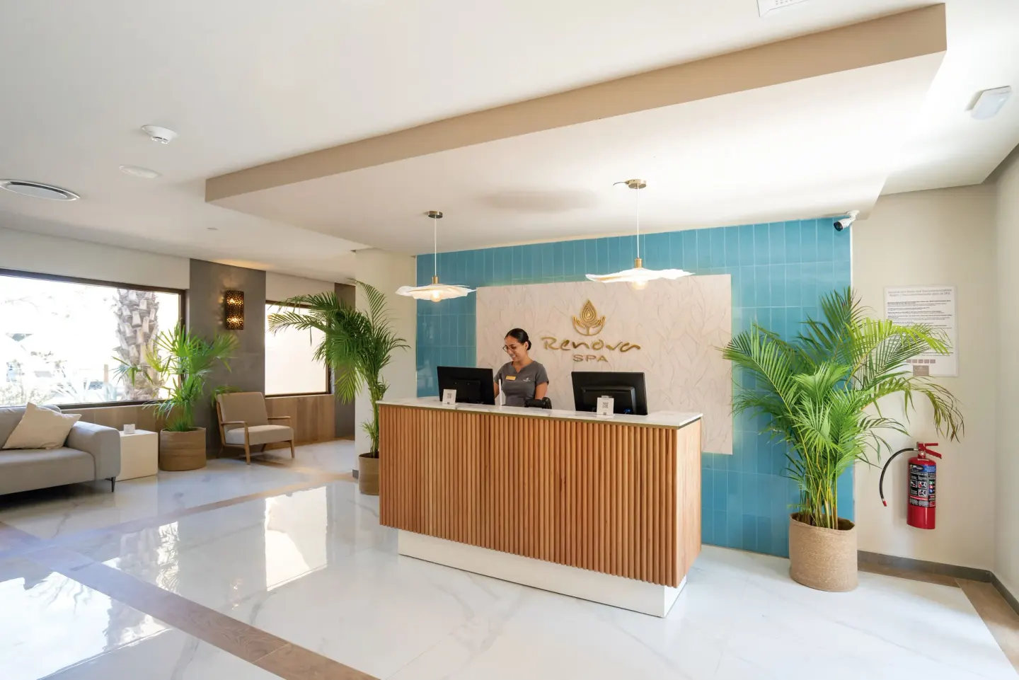 The spa reception desk with plants and blue tile at Hotel Riu Santa Fe.