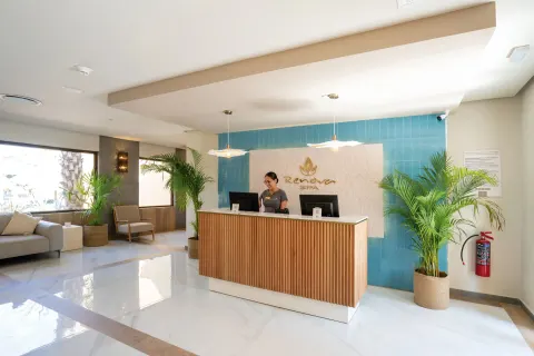 The spa reception desk with plants and blue tile at Hotel Riu Santa Fe.