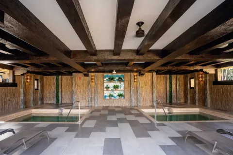 Twin indoor spa pools flank a tiled walkway at Hotel Riu Santa Fe.