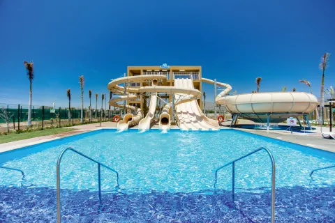 Water slides empty into a bright blue pool at Hotel Riu Santa Fe.