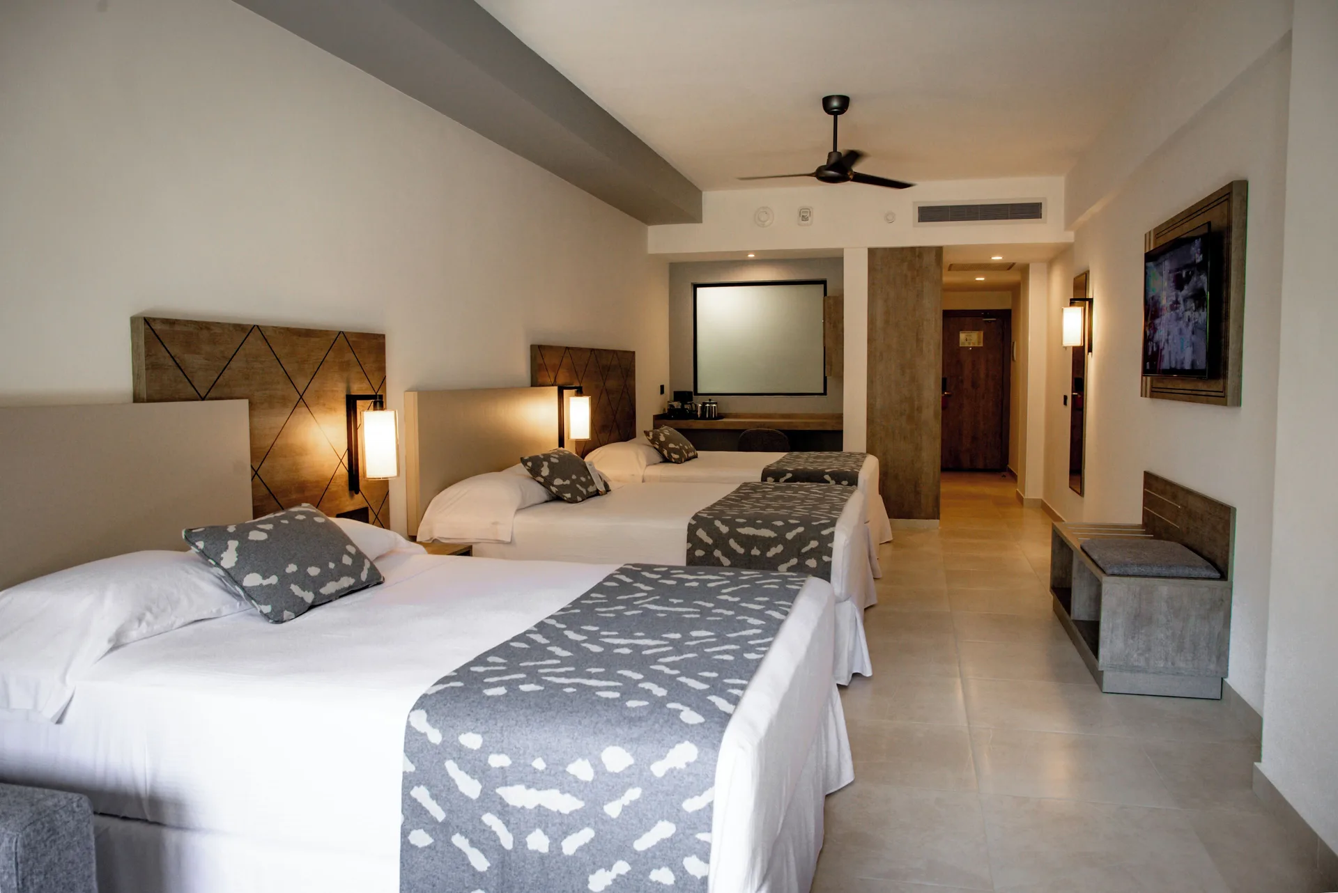 Friends and Family room with three beds and entry area at Hotel Riu Santa Fe.