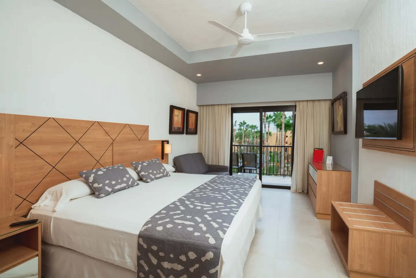 Garden view guest room with king bed and balcony at Hotel Riu Santa Fe.