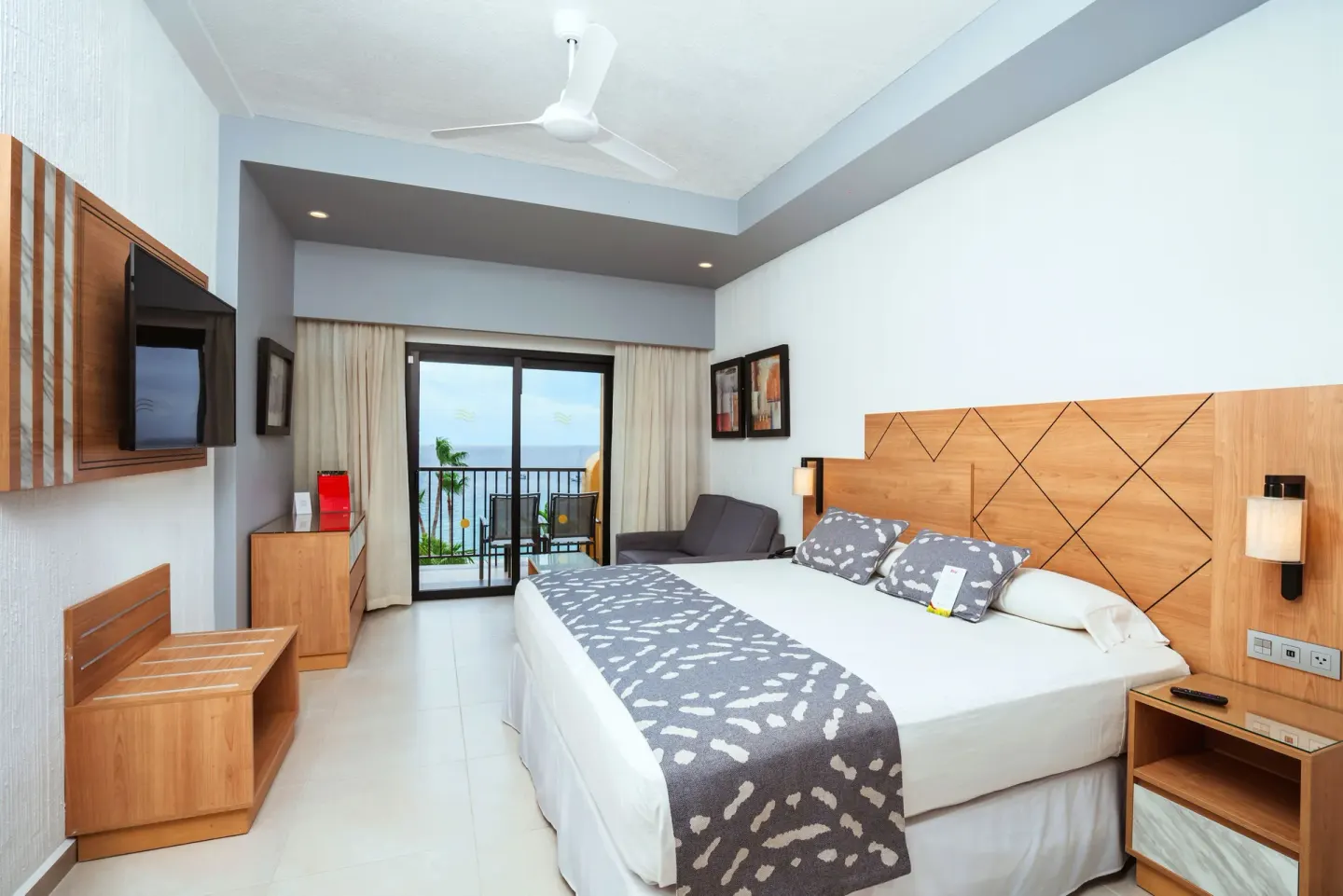 Ocean view guest room with king bed and balcony at Hotel Riu Santa Fe.