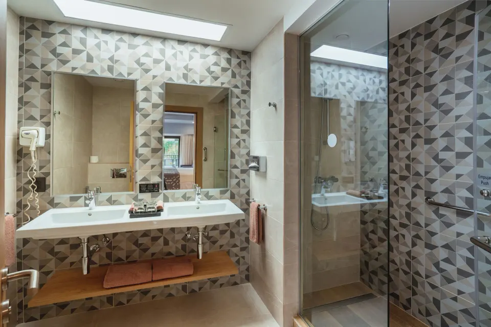 Bathroom vanity and glass shower in a Partial Ocean View room at Hotel Riu Santa Fe.