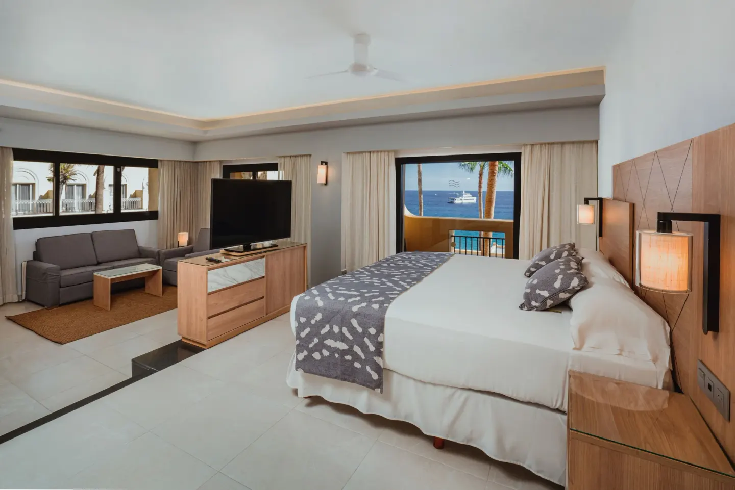 Suite Ocean View bedroom with bed, sofa and balcony sea view at Hotel Riu Santa Fe.