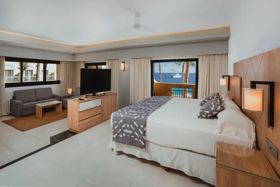 Suite Ocean View bedroom with bed, sofa and balcony sea view at Hotel Riu Santa Fe.