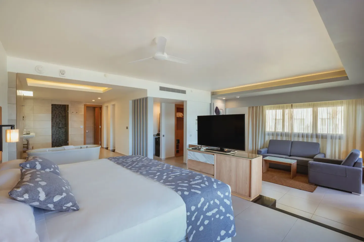 Suite Ocean View room with bed, tub and sitting area at Hotel Riu Santa Fe.