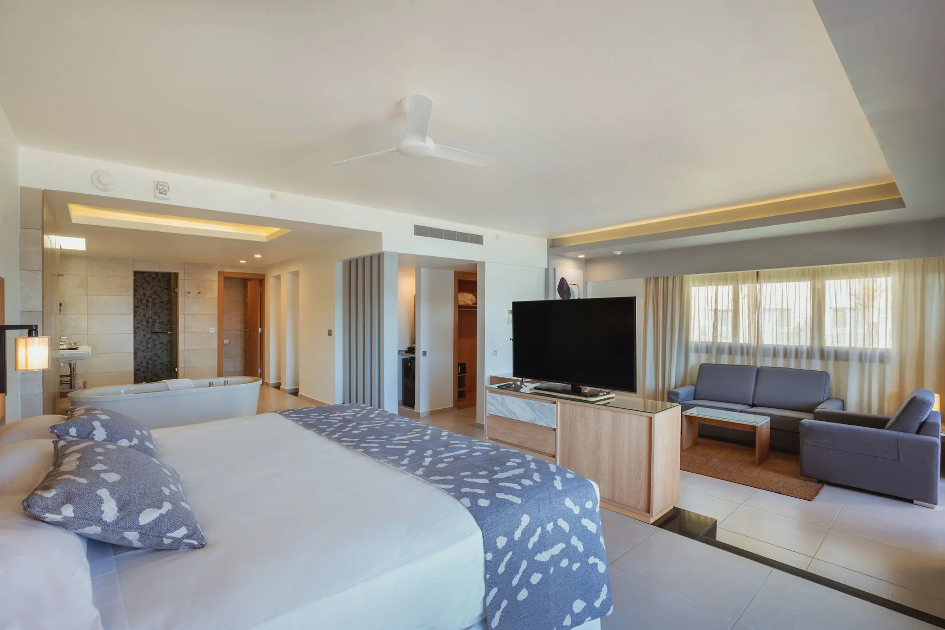Suite Ocean View room with bed, tub and sitting area at Hotel Riu Santa Fe.