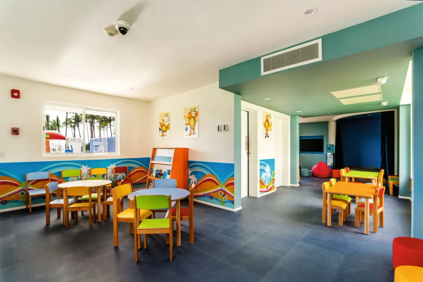 Children's activity room with small tables and colorful chairs at Hotel Riu Vallarta.