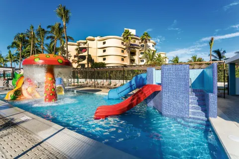 Kids' pool with red and blue slides and mushroom fountain at Hotel Riu Vallarta.