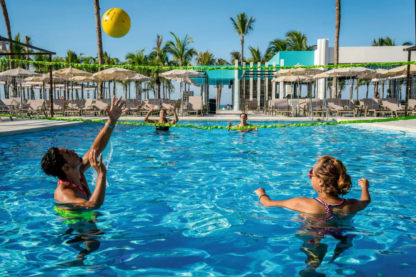Guests playing pool volleyball in the water at Hotel Riu Vallarta.