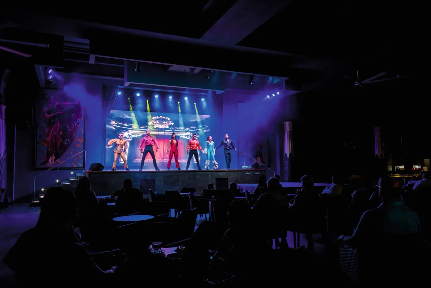 Performers dance on a theater stage before seated guests at Hotel Riu Vallarta.