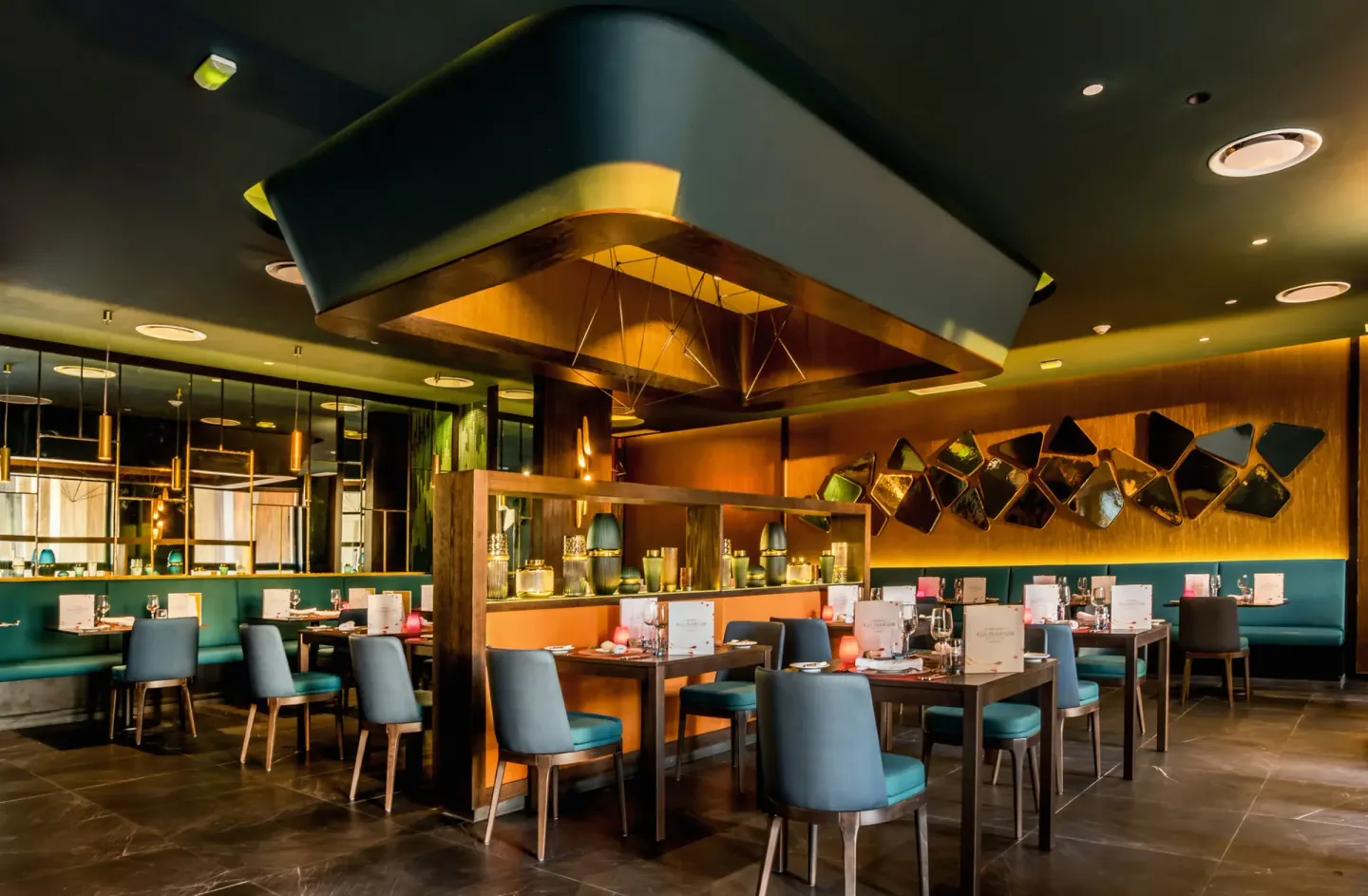 Kulinarium dining room with teal chairs and gold lighting at Hotel Riu Vallarta.