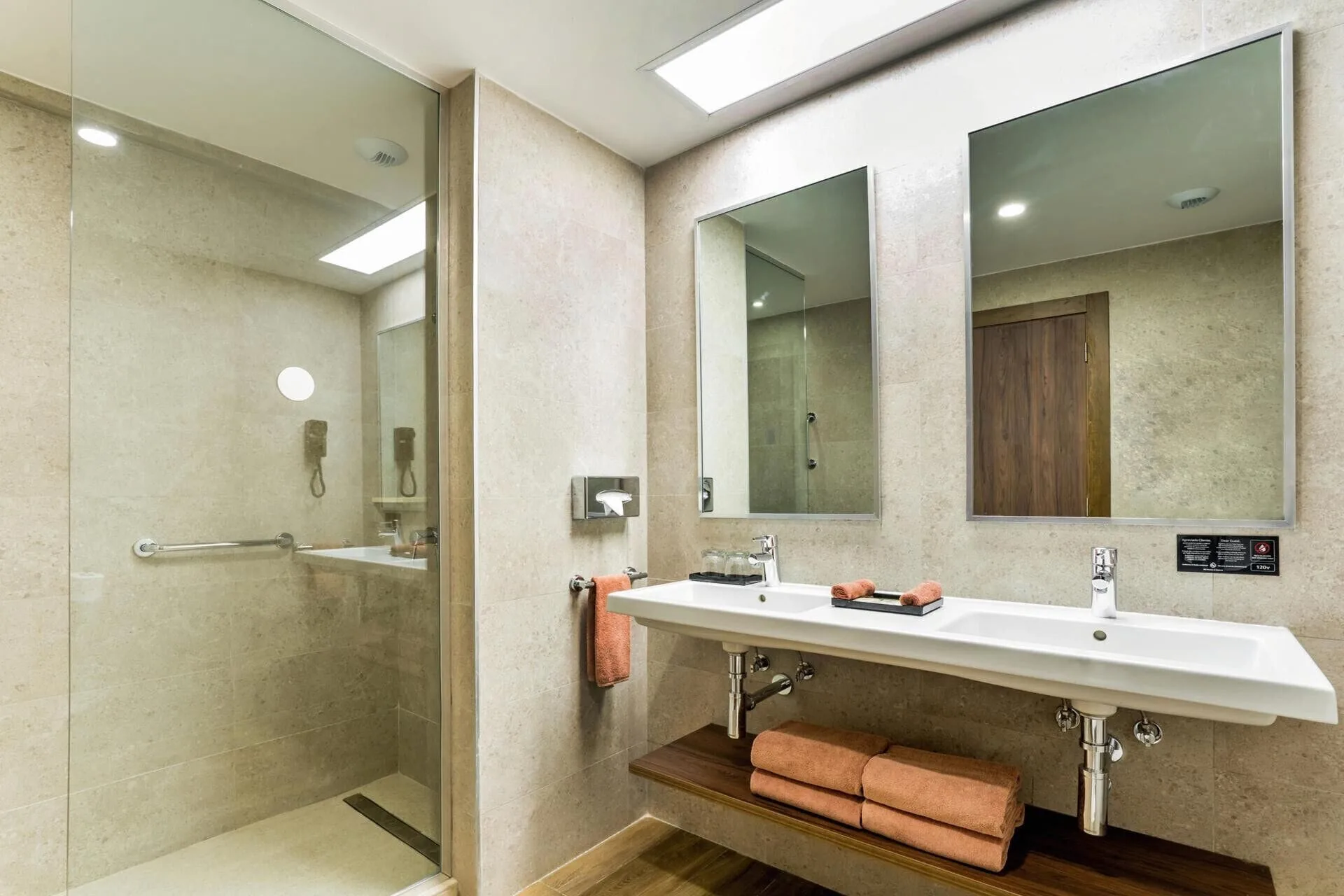 Family Room bathroom with double sink vanity and glass shower at Hotel Riu Vallarta.