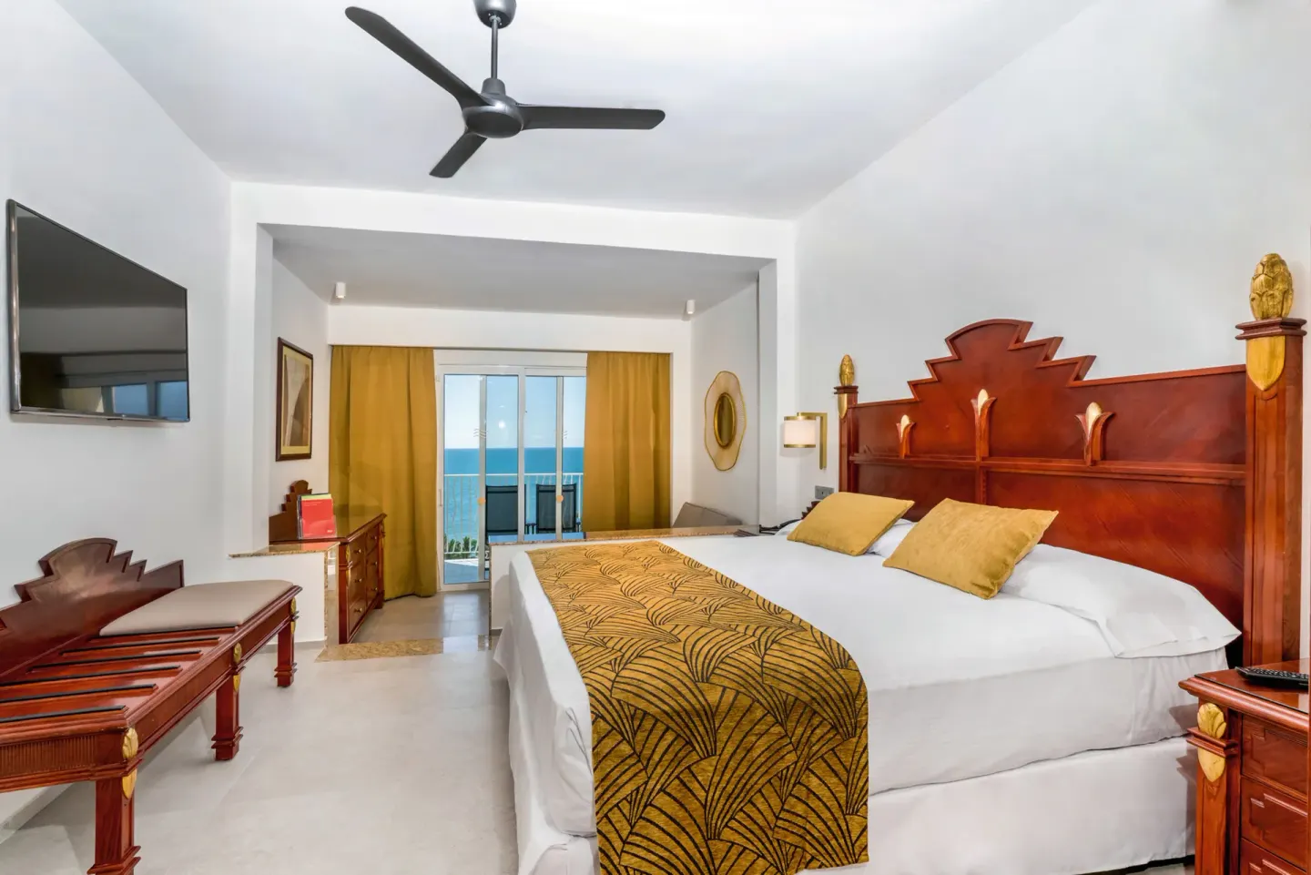 Junior Suite Ocean View guest room with bed and balcony at Hotel Riu Vallarta.